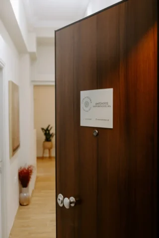 Μια ξύλινη πόρτα με μια πινακίδα προσαρτημένη σε αυτήν, που υποδεικνύει το δωμάτιο ή την περιοχή από πίσω.